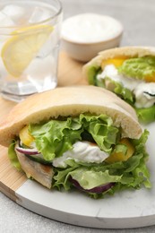 Photo of Delicious pita sandwiches with chicken breast and vegetables on board, closeup