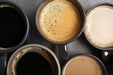 Many cups with tasty aromatic coffee on table, flat lay