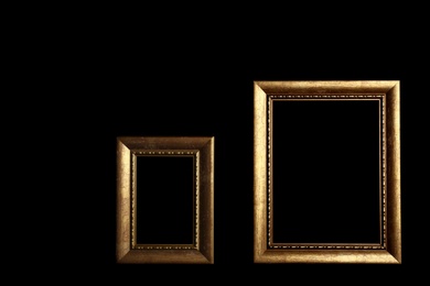 Photo of Empty golden frames on black background. Space for design