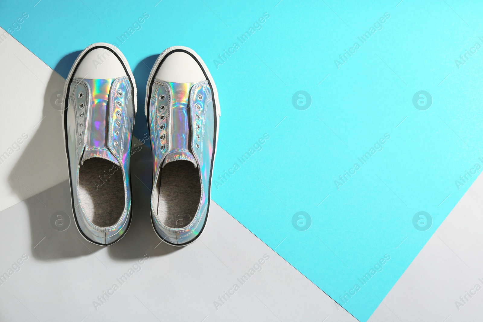 Photo of Pair of stylish sneakers on color background, top view with space for text