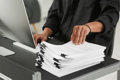 Photo of Man working with documents at grey table in office, closeup