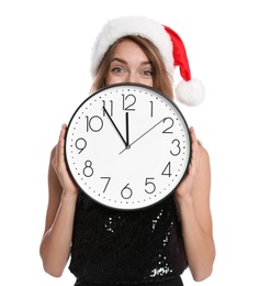 Happy young woman in Santa hat holding clock on white background. Christmas celebration