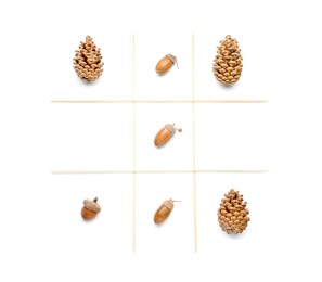 Photo of Tic tac toe game made with acorns and conifer cones isolated on white, top view