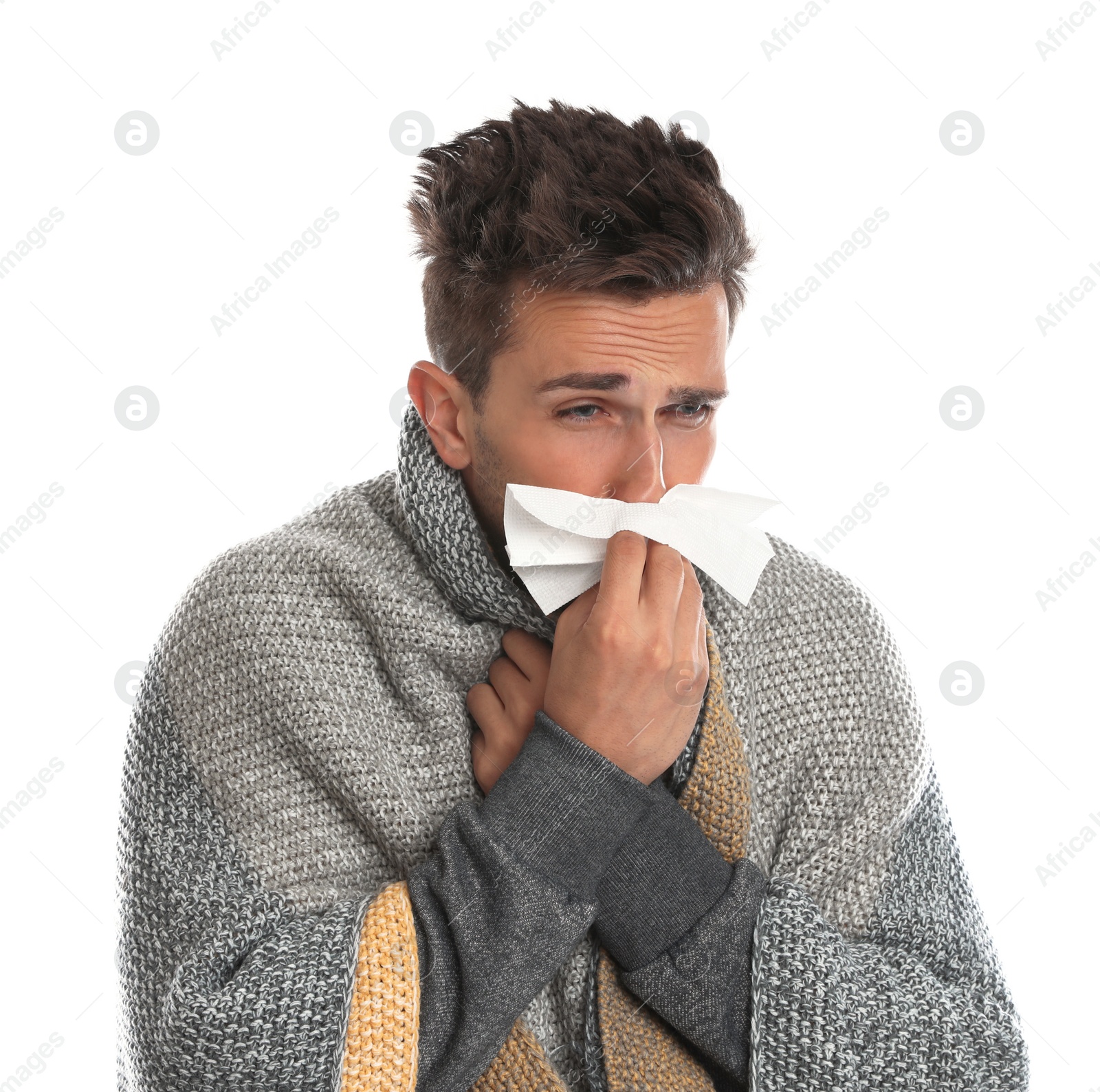 Photo of Young man wrapped in warm blanket suffering from cold on white background