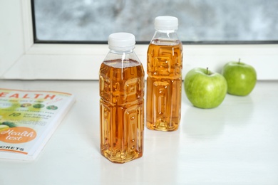 Bottles of apple juice on window sill