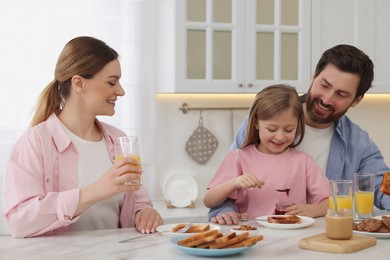 Happy family having breakfast at table in kitchen