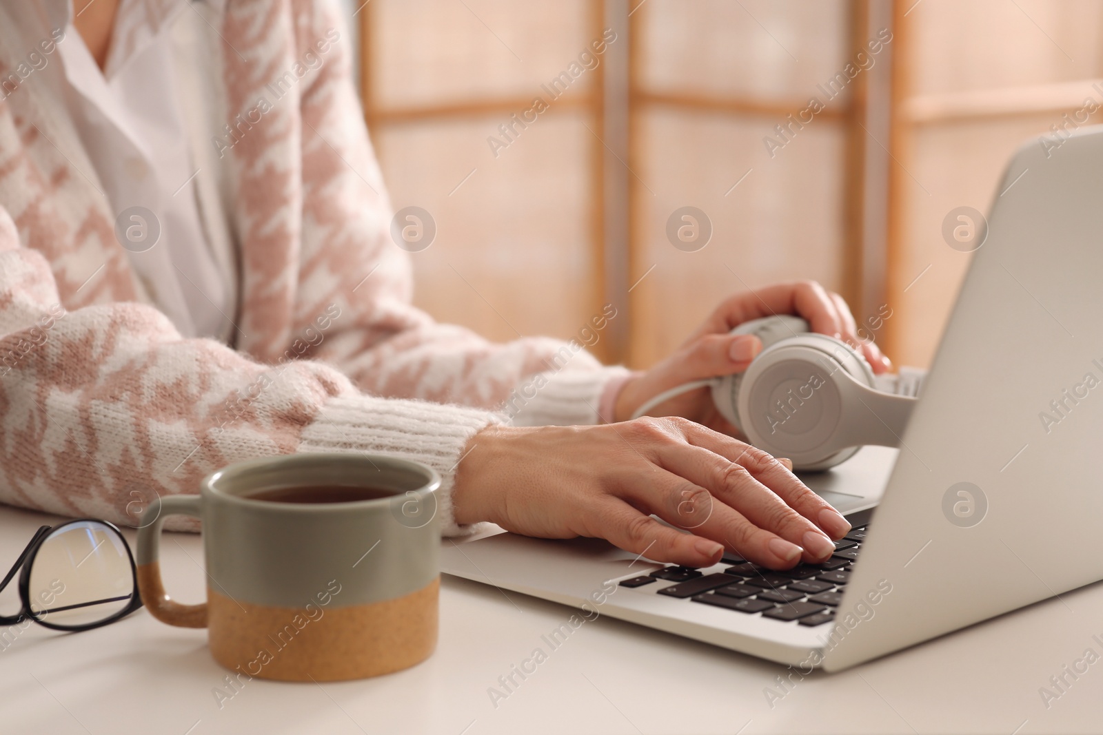 Photo of Woman with modern laptop learning at table indoors, closeup