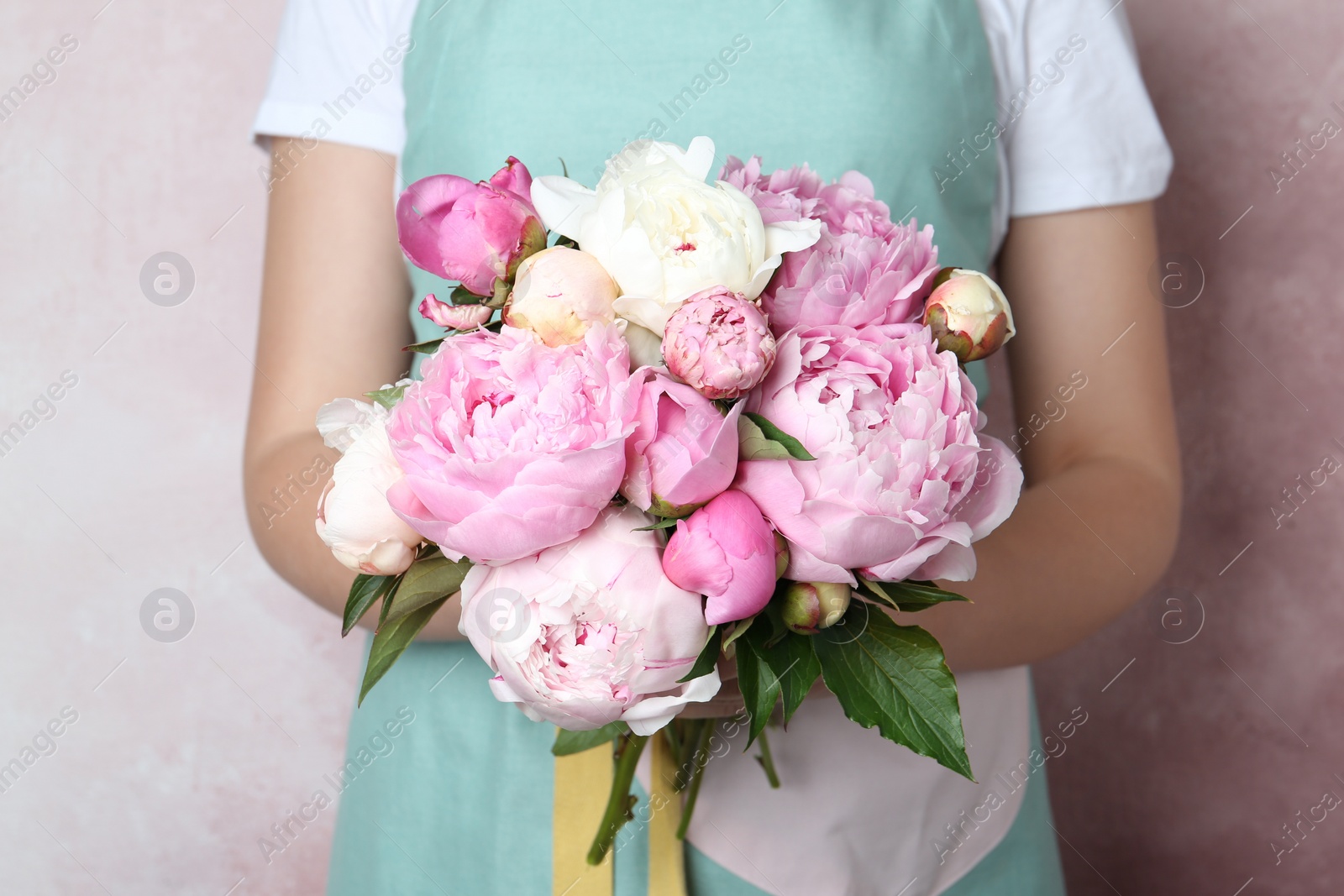 Photo of Woman with bouquet of beautiful peonies on pink background, closeup