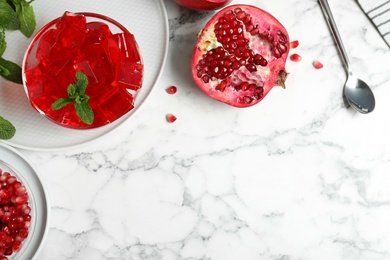 Photo of Flat lay composition with pomegranate jelly in bowl on marble table. Space for text