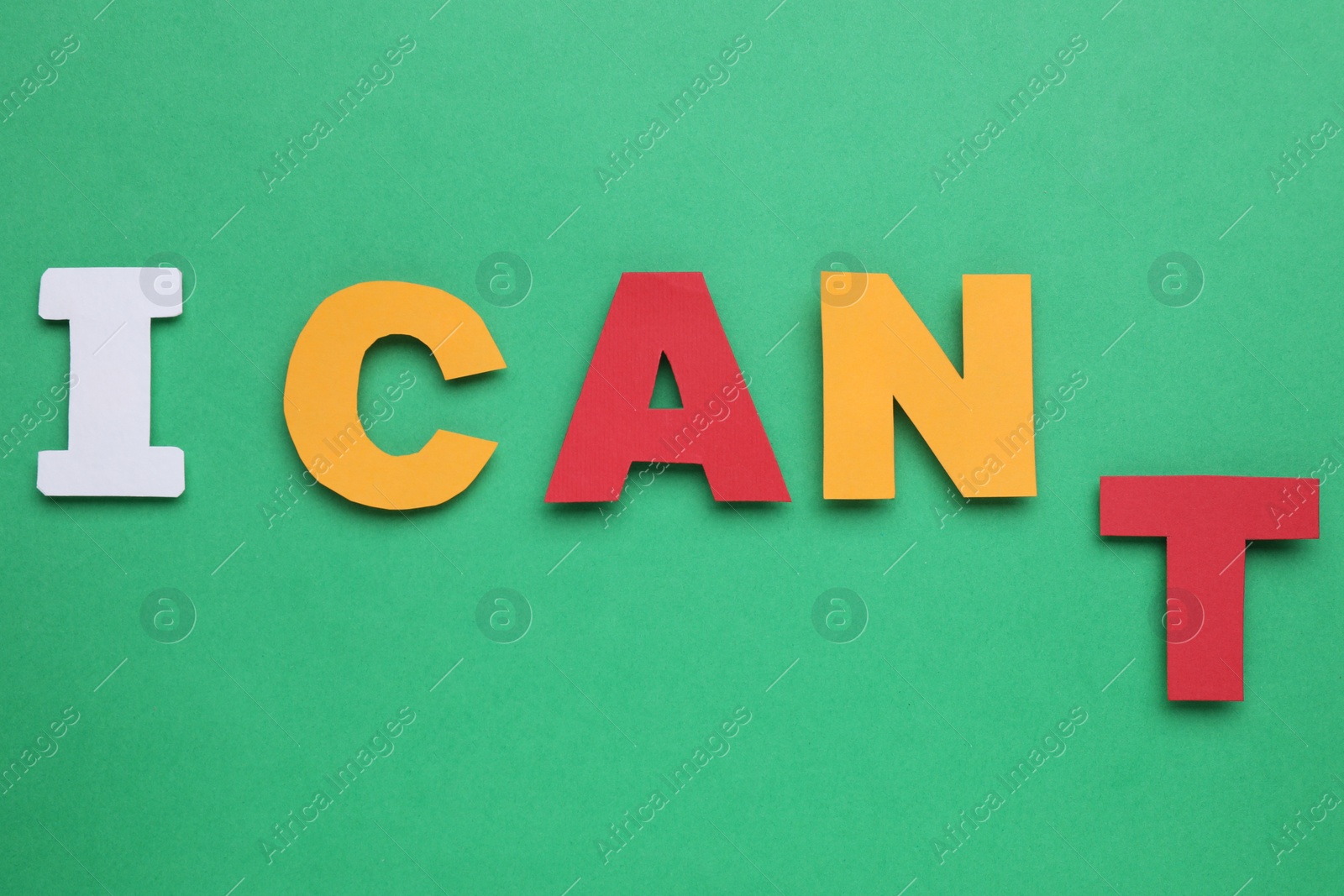 Photo of Motivation concept. Changing phrase from I Can't into I Can by removing paper letter T on green background, top view