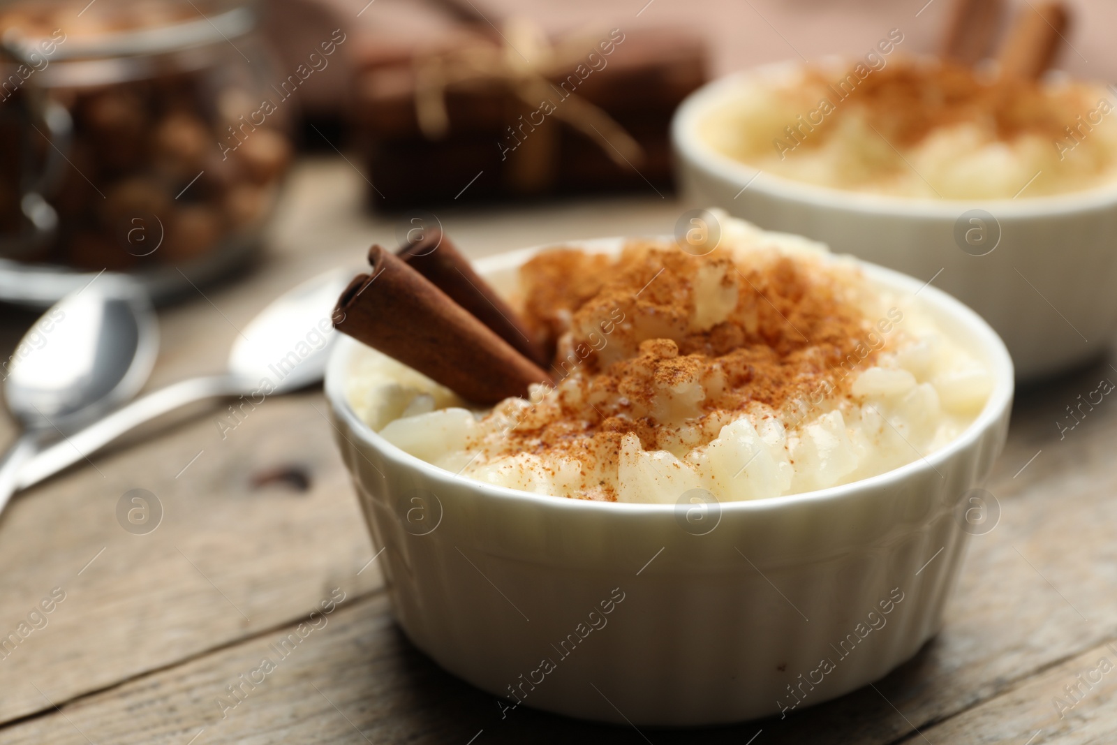 Photo of Delicious rice pudding with cinnamon on wooden table, closeup