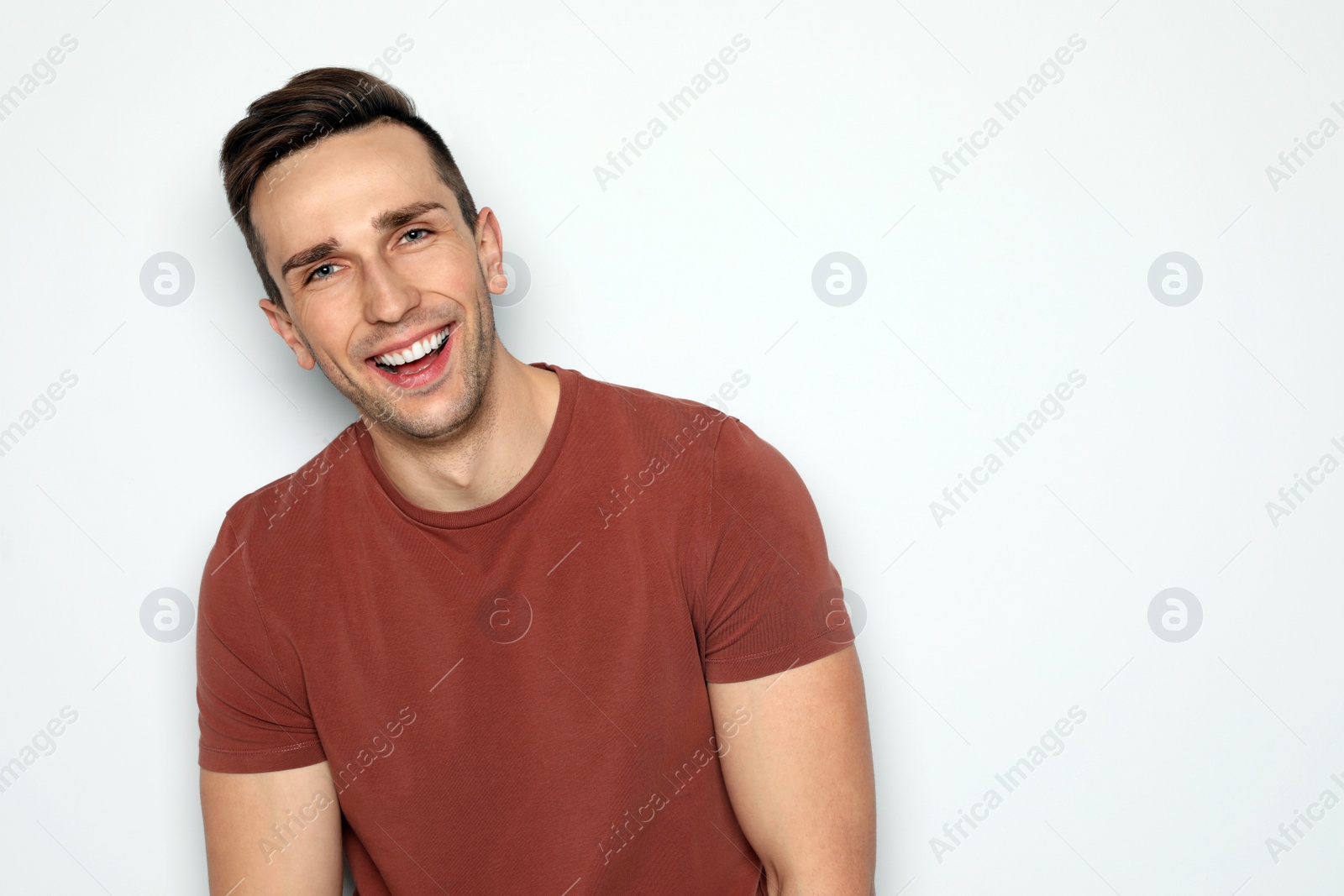 Photo of Portrait of handsome man laughing against light background. Space for text