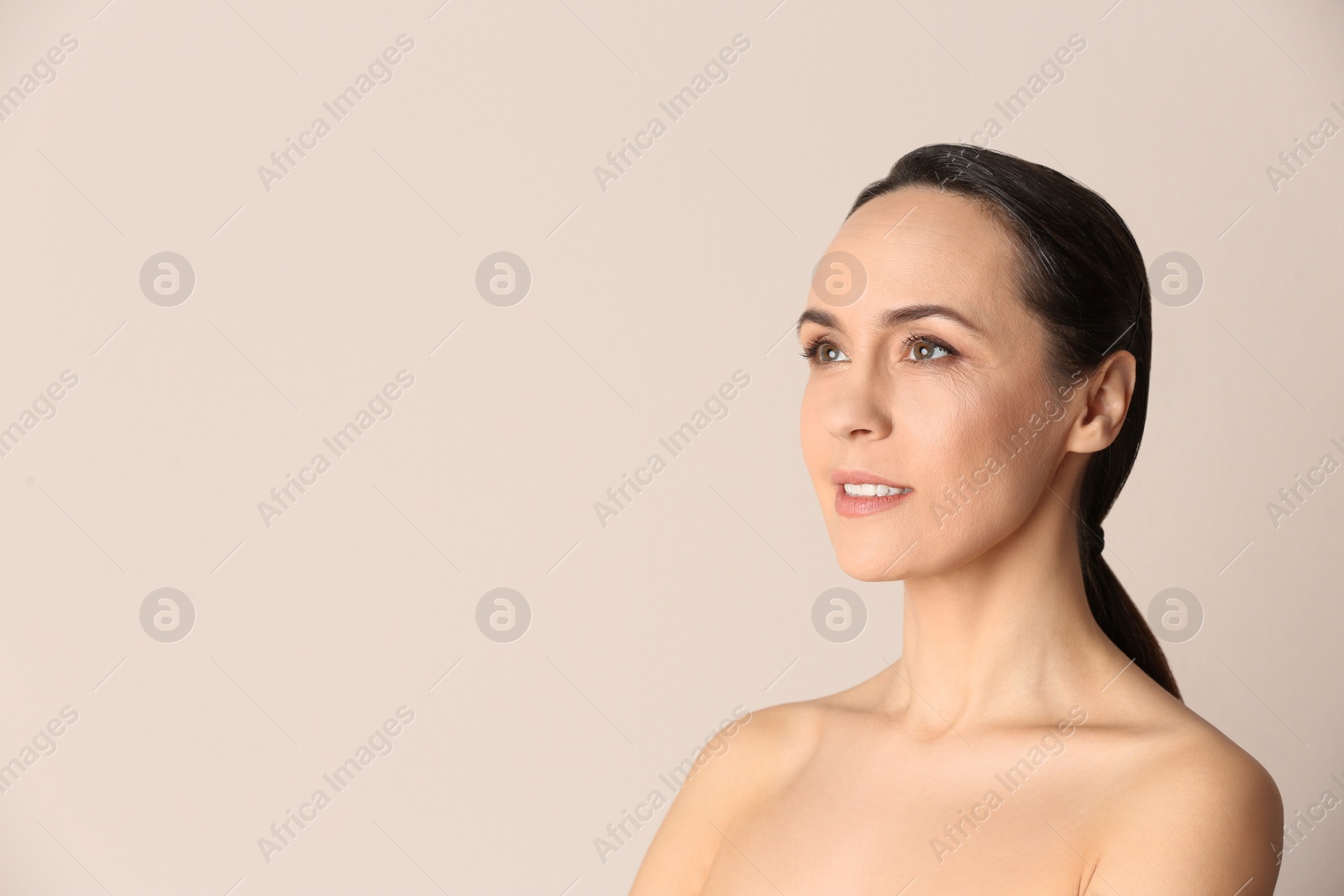 Photo of Portrait of beautiful mature woman on beige background. Space for text