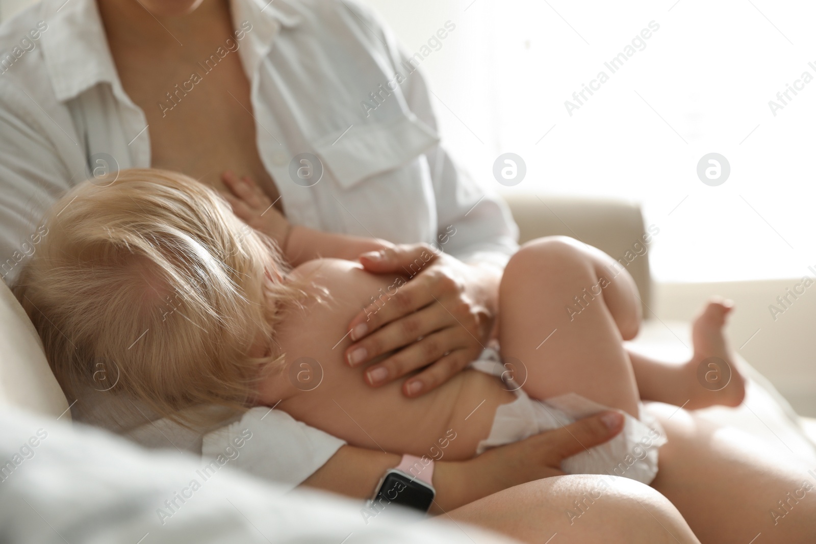 Photo of Mother breastfeeding her little baby at home. Healthy growth