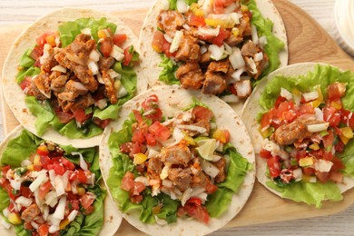 Photo of Delicious tacos with vegetables and meat on table, flat lay