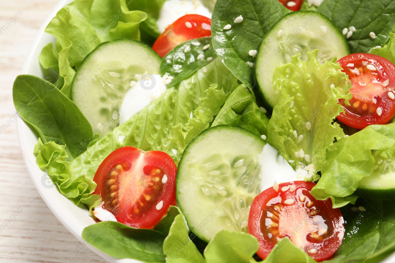 Photo of Delicious salad in bowl on white table, closeup