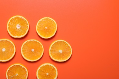 Slices of juicy orange on terracotta background, flat lay. Space for text