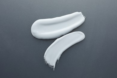 Photo of Sample of facial cream on gray background, top view