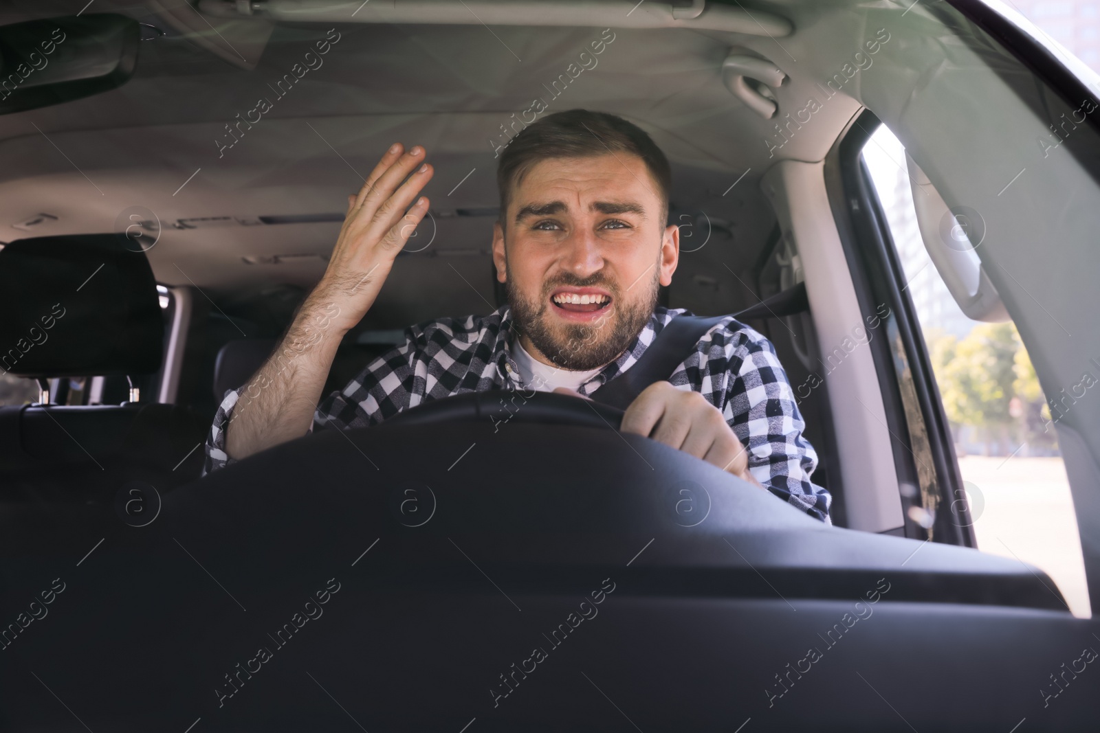 Photo of Emotional man in car. Aggressive driving behavior