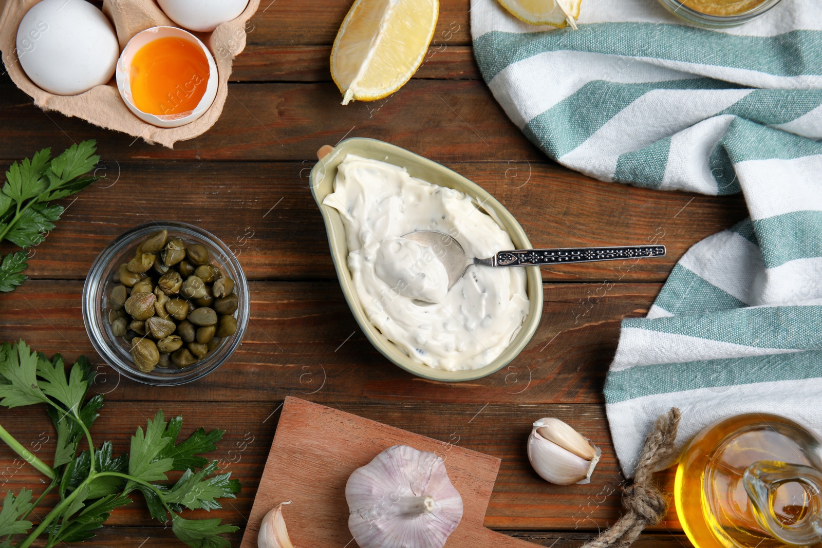 Photo of Tasty tartar sauce and ingredients on wooden table, flat lay