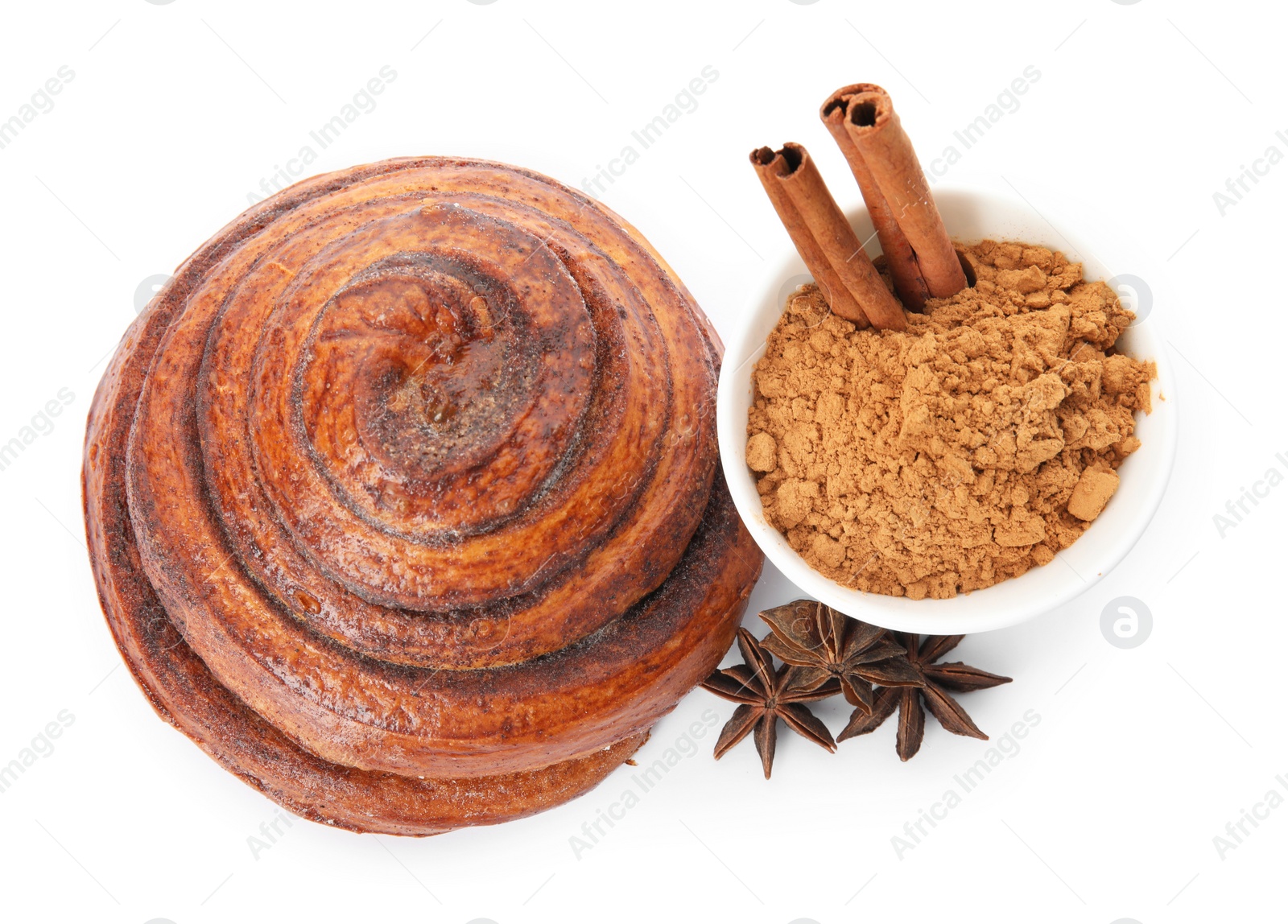 Photo of Freshly baked cinnamon roll with ingredients on white background, top view