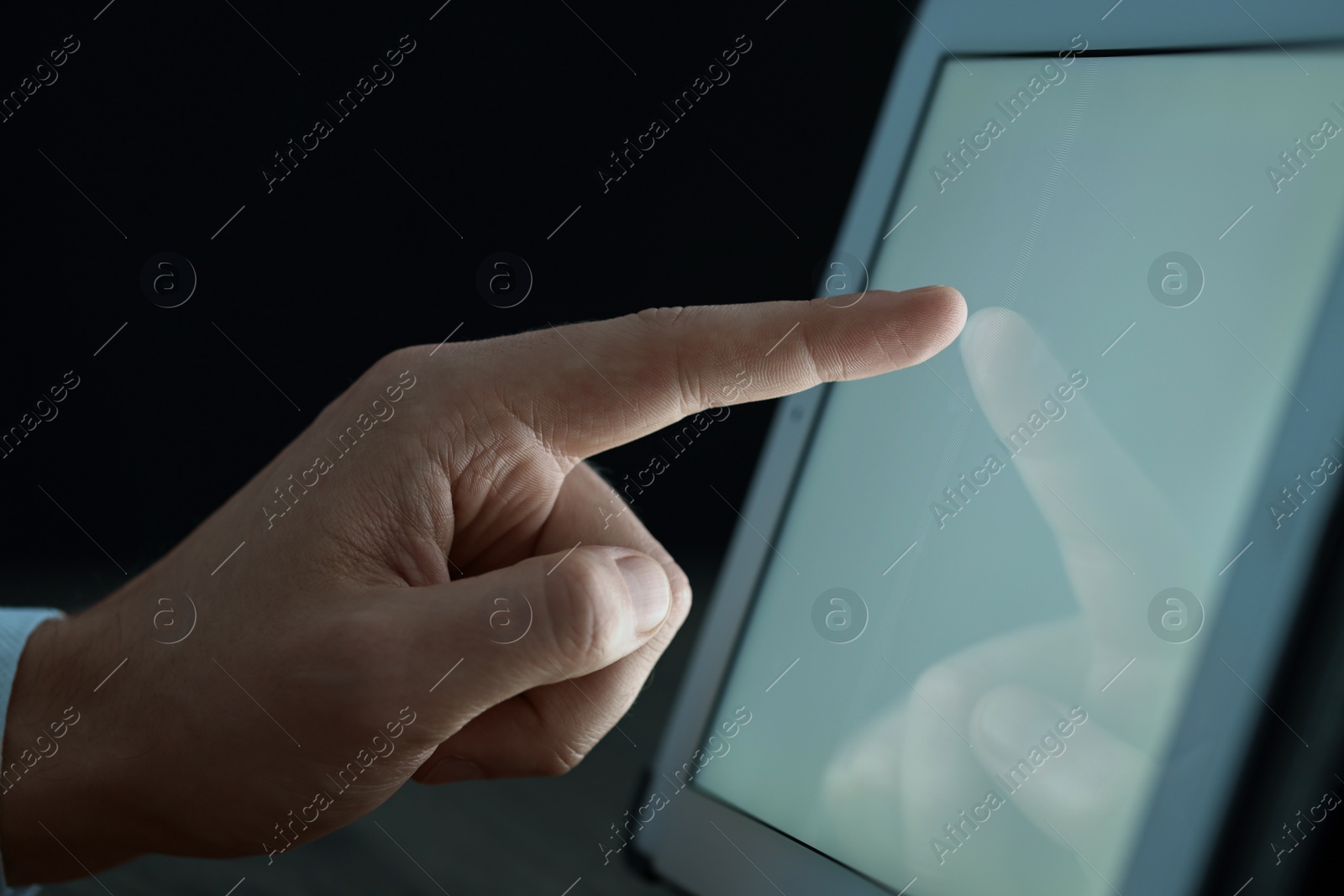 Photo of Man using tablet at night, closeup view