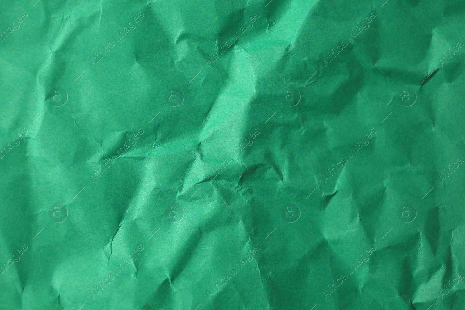 Photo of Sheet of crumpled green paper as background, top view