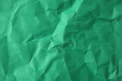 Sheet of crumpled green paper as background, top view