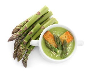 Photo of Delicious asparagus soup with rusks isolated on white, top view