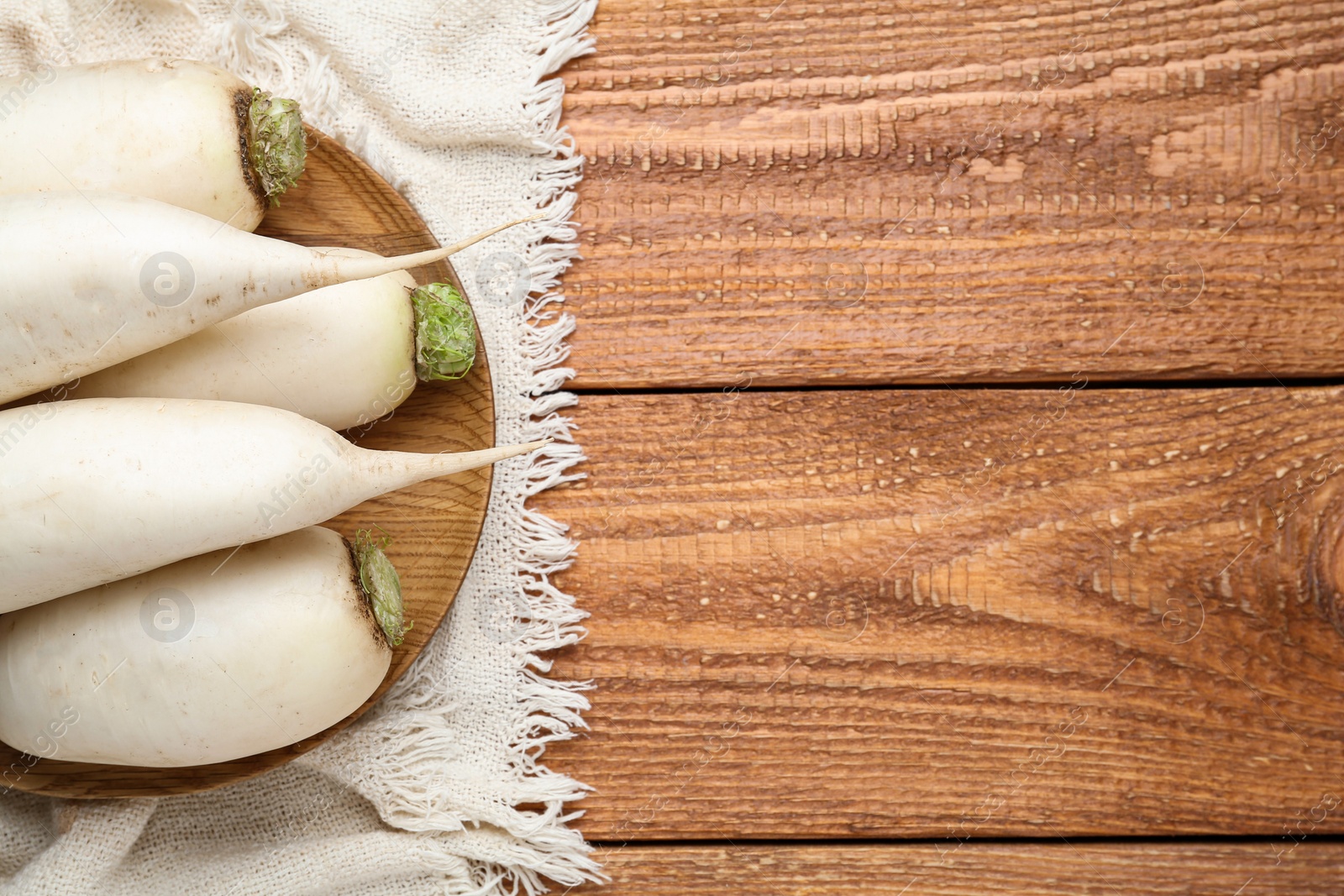 Photo of White turnips on wooden table, flat lay. Space for text