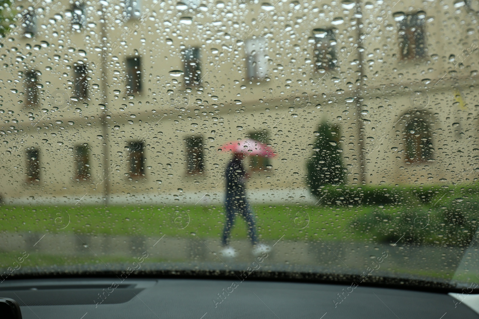 Photo of Blurred view of city street through wet car window. Rainy weather