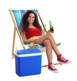 Photo of Happy young African American woman with bottle of beer resting in deck chair near cool box on white background