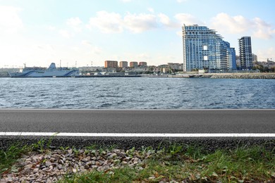 Image of Empty asphalt road, beautiful view of cityscape and river on sunny day