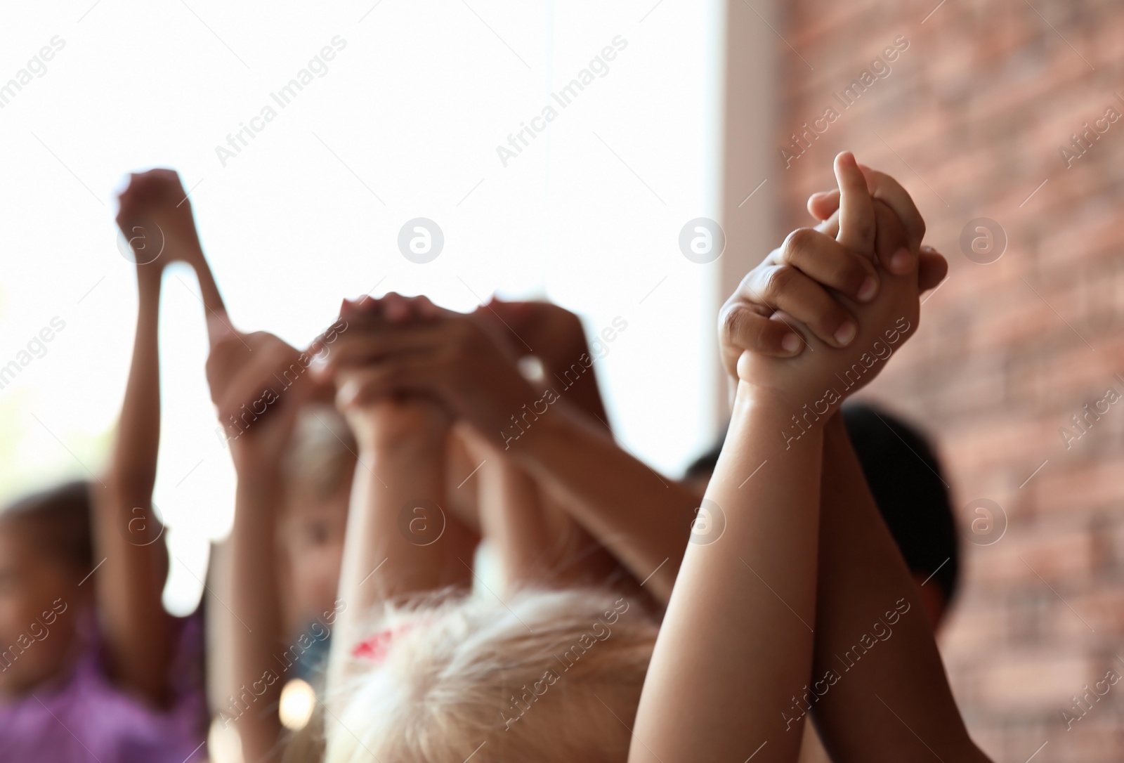 Photo of Little children holding hands together indoors. Unity concept