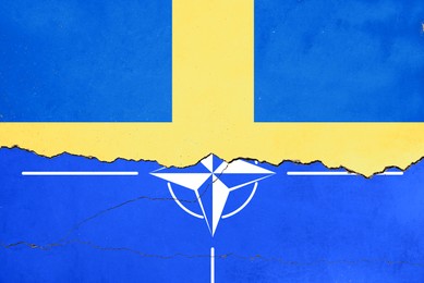 Flags of Sweden and NATO on broken wall