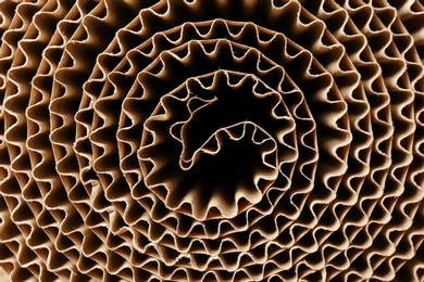 Photo of Roll of brown corrugated cardboard, closeup. Recyclable material