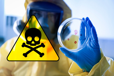 Poison sign and scientist holding Petri dish in laboratory, focus on hand 