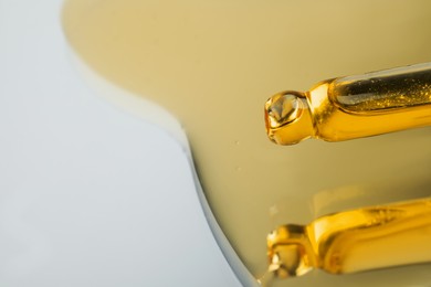 Photo of Yellow serum with pipette on mirror, closeup. Space for text