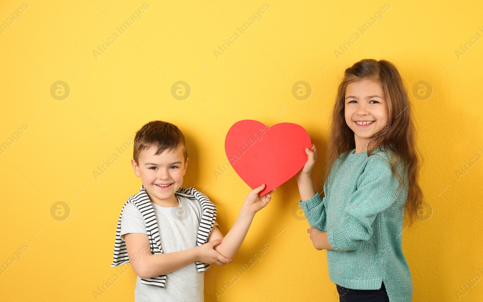 Photo of Happy children holding paper heart on color background