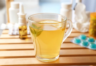 Hot tea with lemon for cold on wooden table