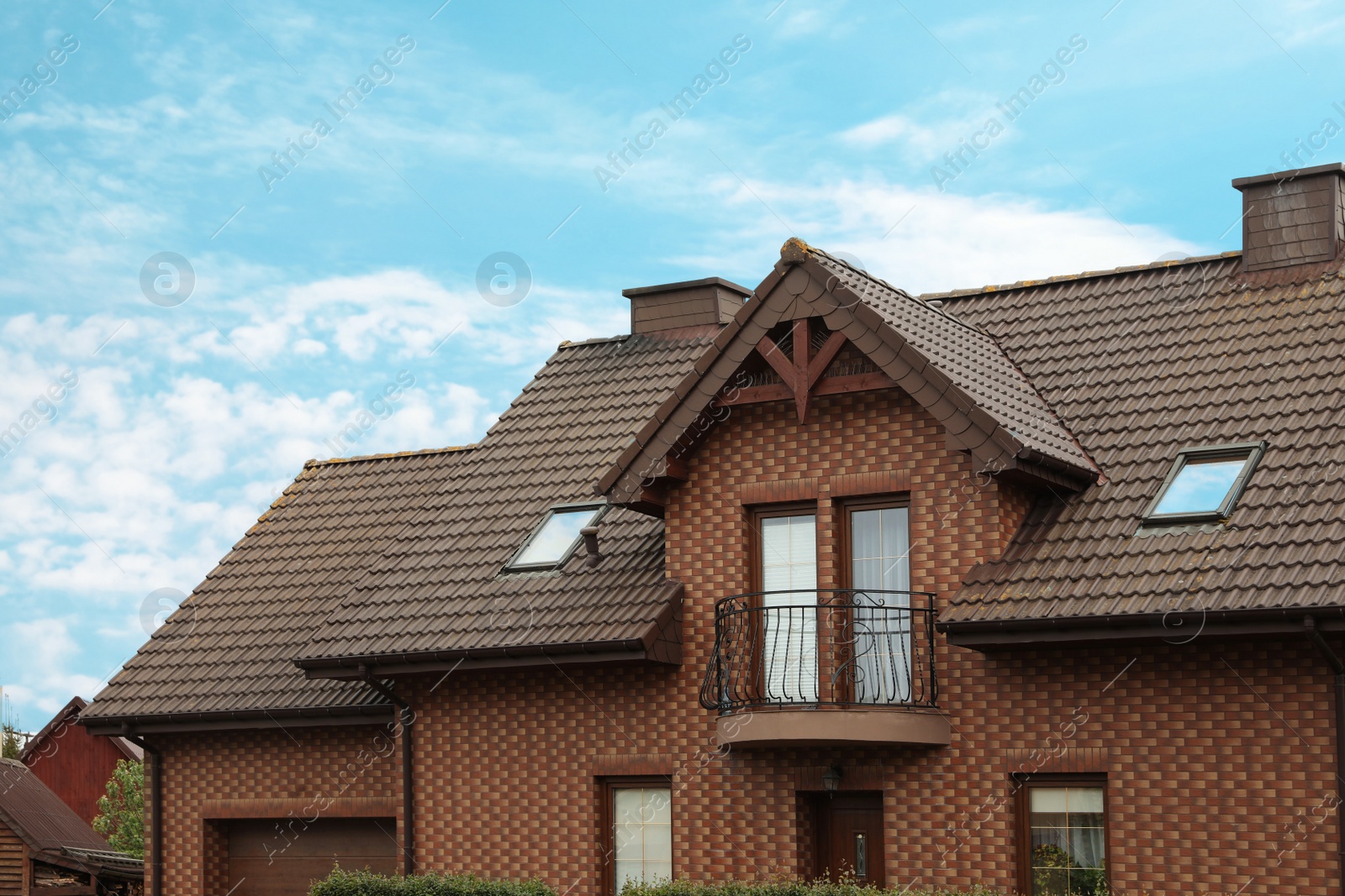 Photo of Beautiful house with brown roof against blue sky