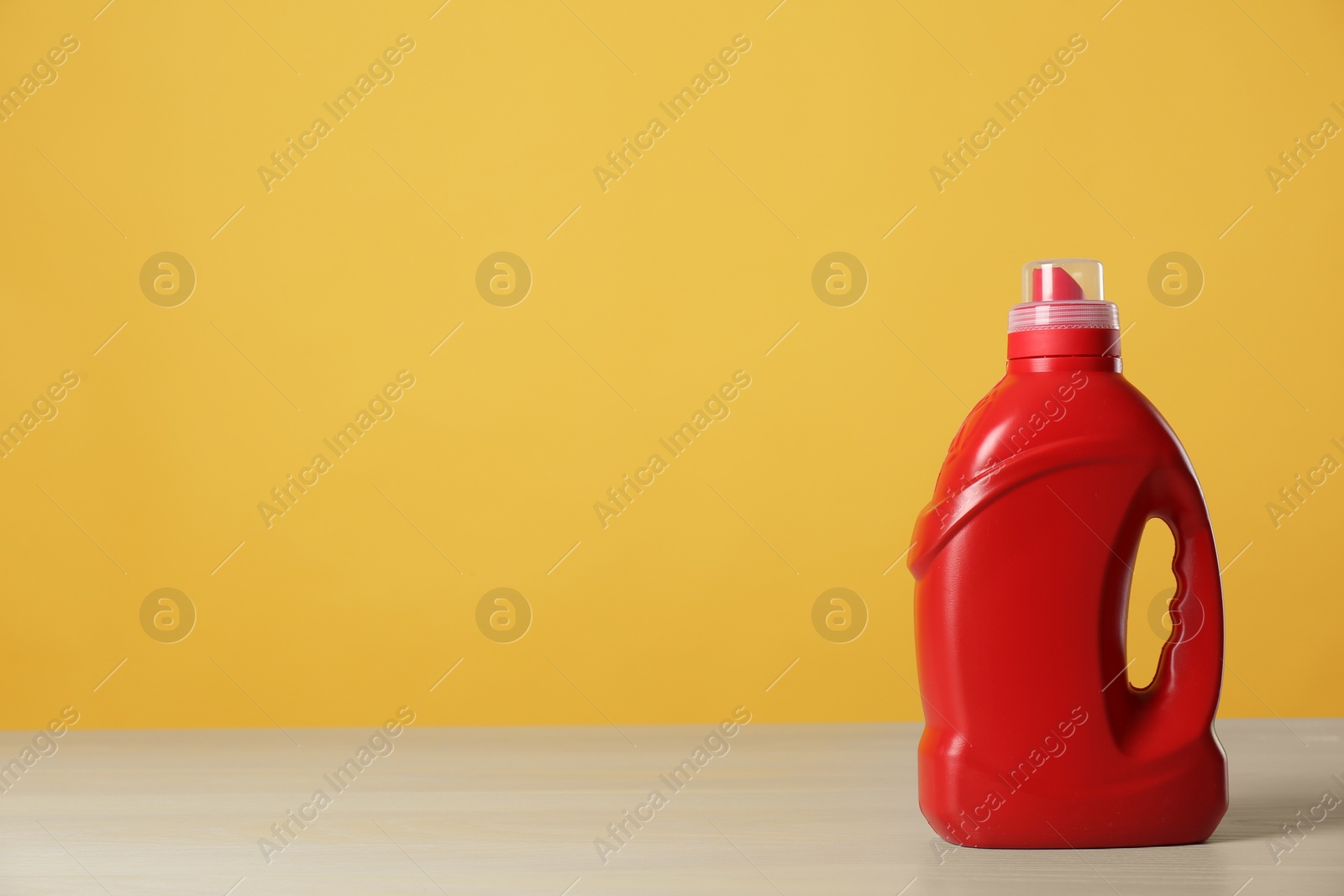 Photo of Bottle of cleaning product on light table. Space for text