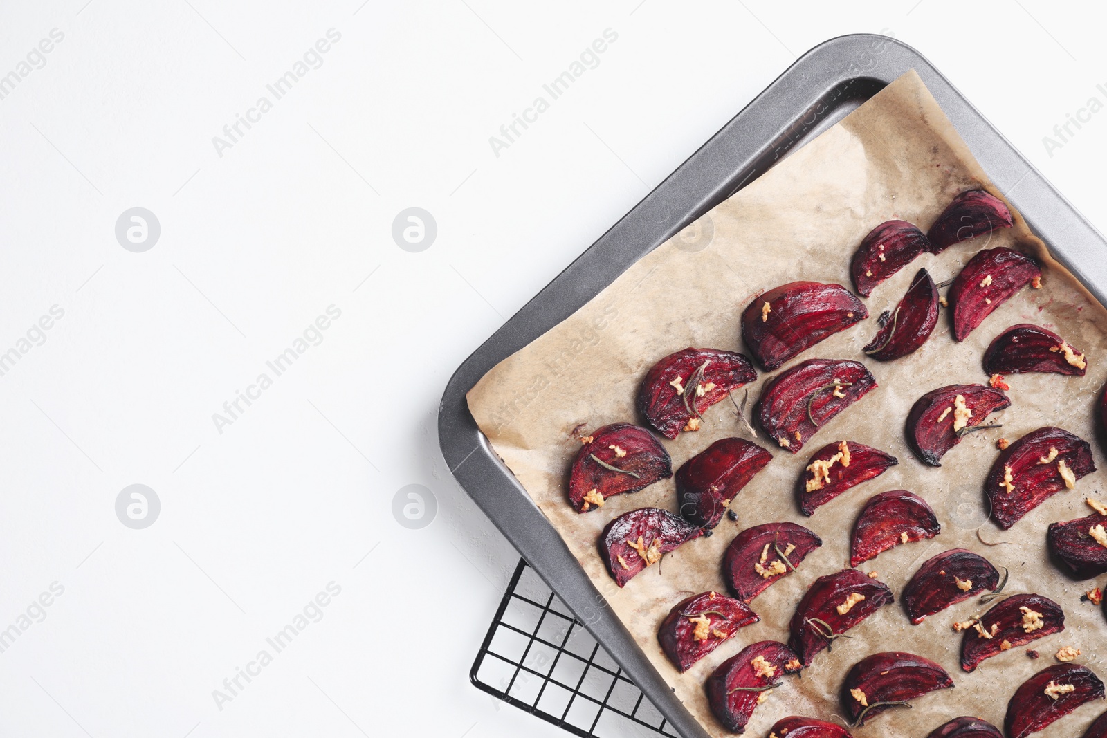 Photo of Baking tray with roasted beetroot slices on white table, top view. Space for text