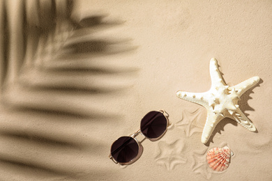Photo of Flat lay composition with sunglasses on sand, space for text. Beach objects
