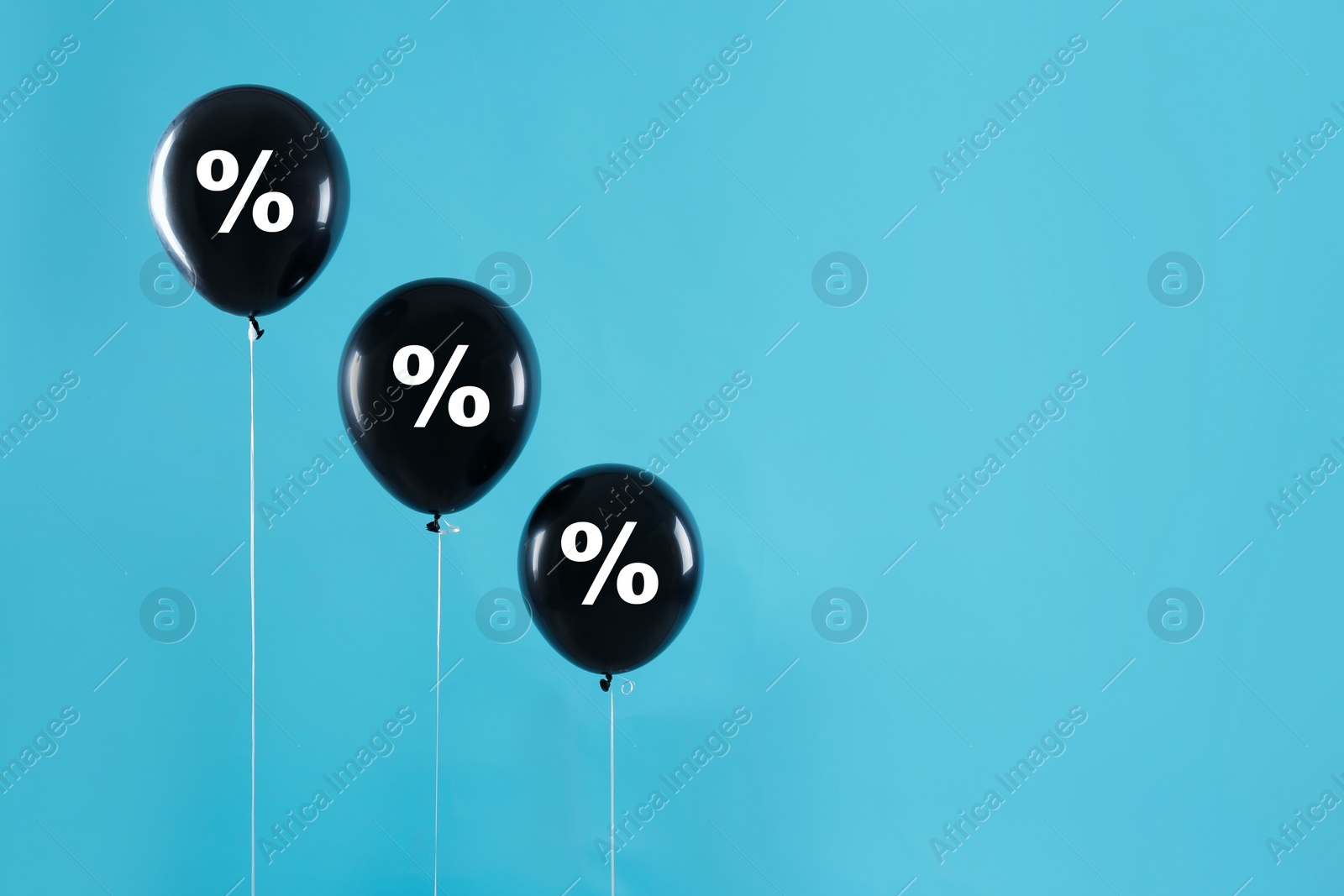 Image of Discount offer. Black balloons with percent sign on light blue background, space for text