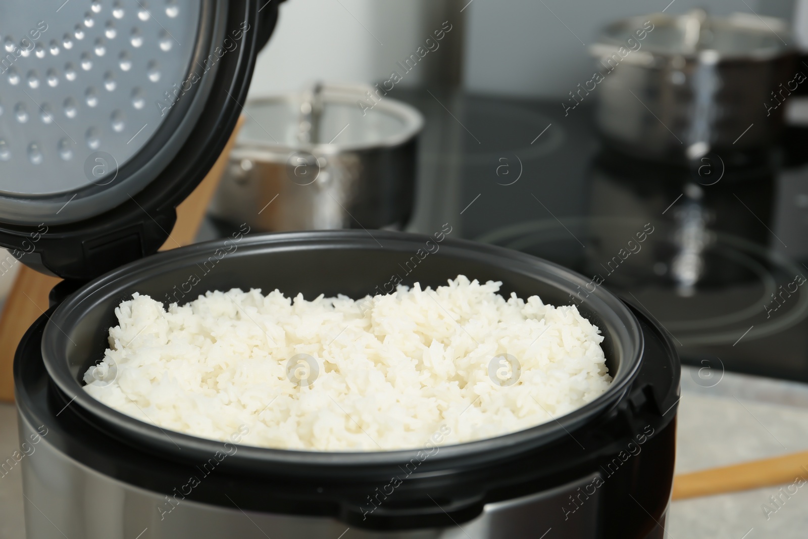 Photo of Modern cooker with fresh boiled rice in kitchen