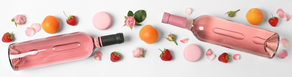 Photo of Composition with bottles of delicious rose wine on white background, top view