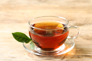 Photo of Cup of black tea on wooden table