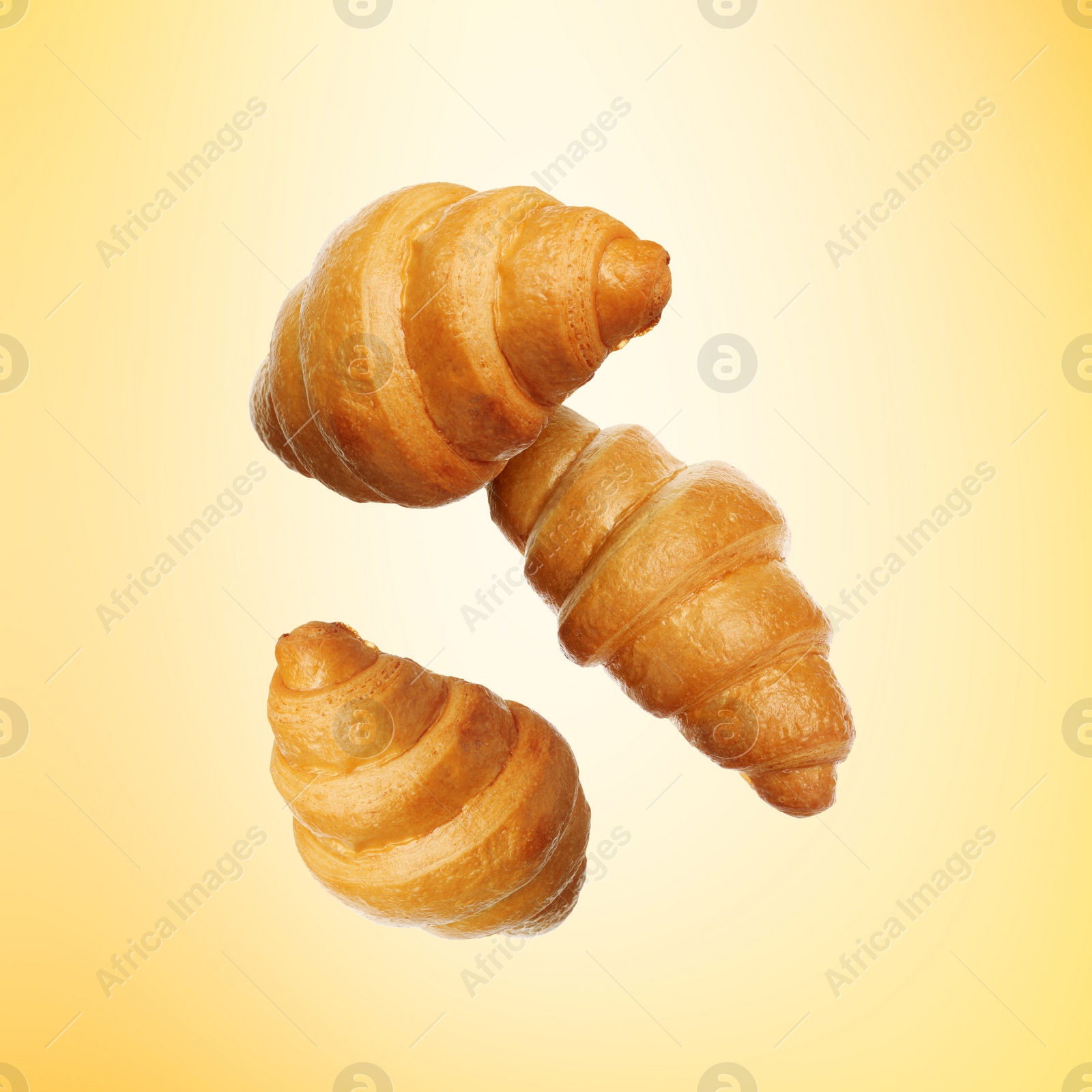 Image of Golden croissants falling on golden gradient background