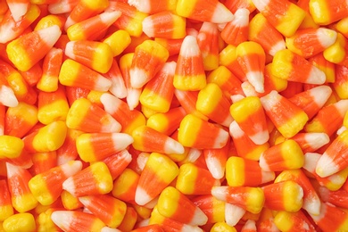 Photo of Delicious candy corns as background, top view